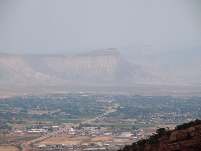 [A mostly greyed view of towering mountains surrounding the trees and buildings in the canyon.]